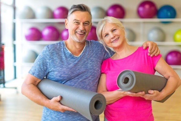 Active aging adults participating in group exercise classes at the senior living community workout center.