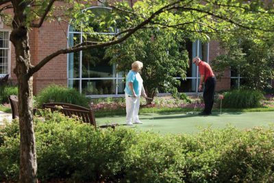 Image showcasing daily living at our independent living facility as aging adults play a round of mini-putt