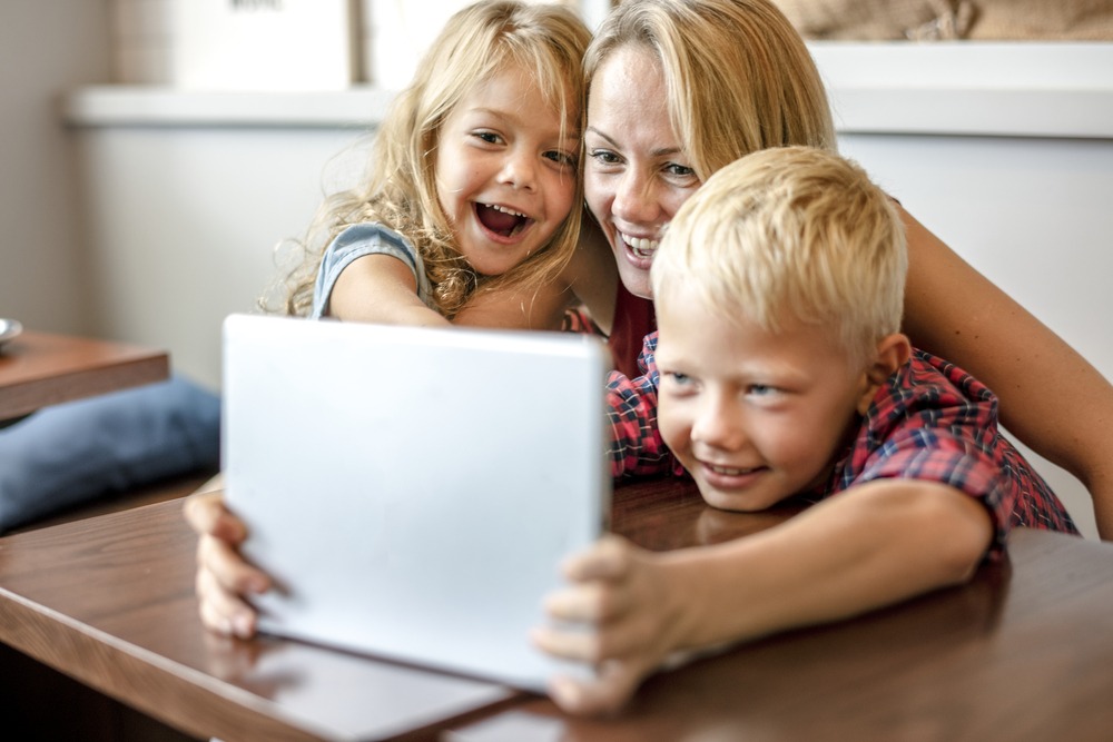 Mom watching an online video with her kids Game night virtual hangout