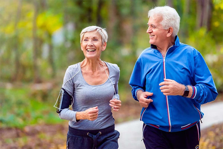 Healthy senior couple jogging and has increased mobility which is one of the benefits of physical therapy for seniors.