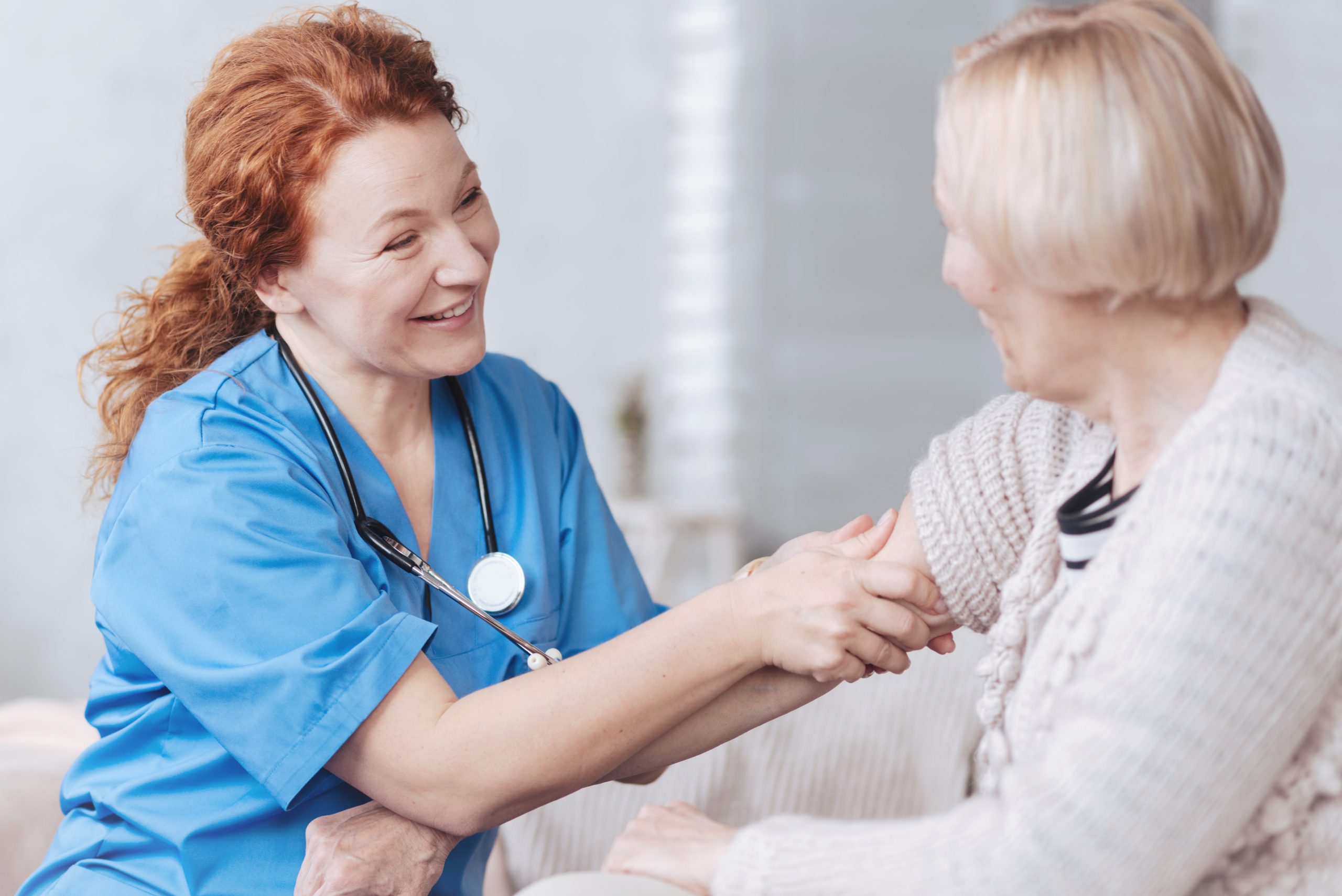 Nurse massaging the arm of the senior lady. A skilled Nurse assisting an resident at our worry-free retirement living center in Media, PA