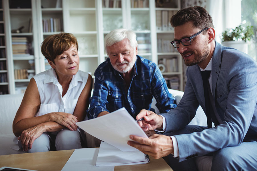 Senior couple inquiring about lifecare planning from an insurance agent. Senior couple inquiring about lifecare planning from an insurance agent.