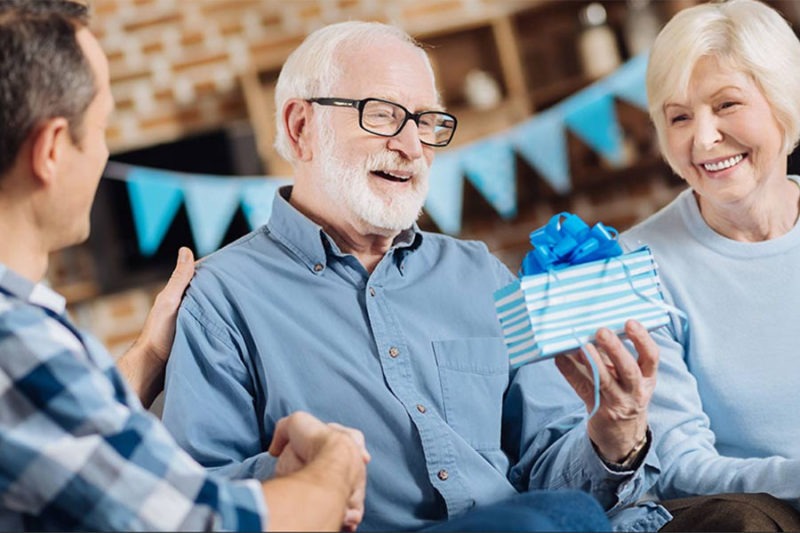 Senior man receiving a gift concept image for what is a good retirement gift for a man.