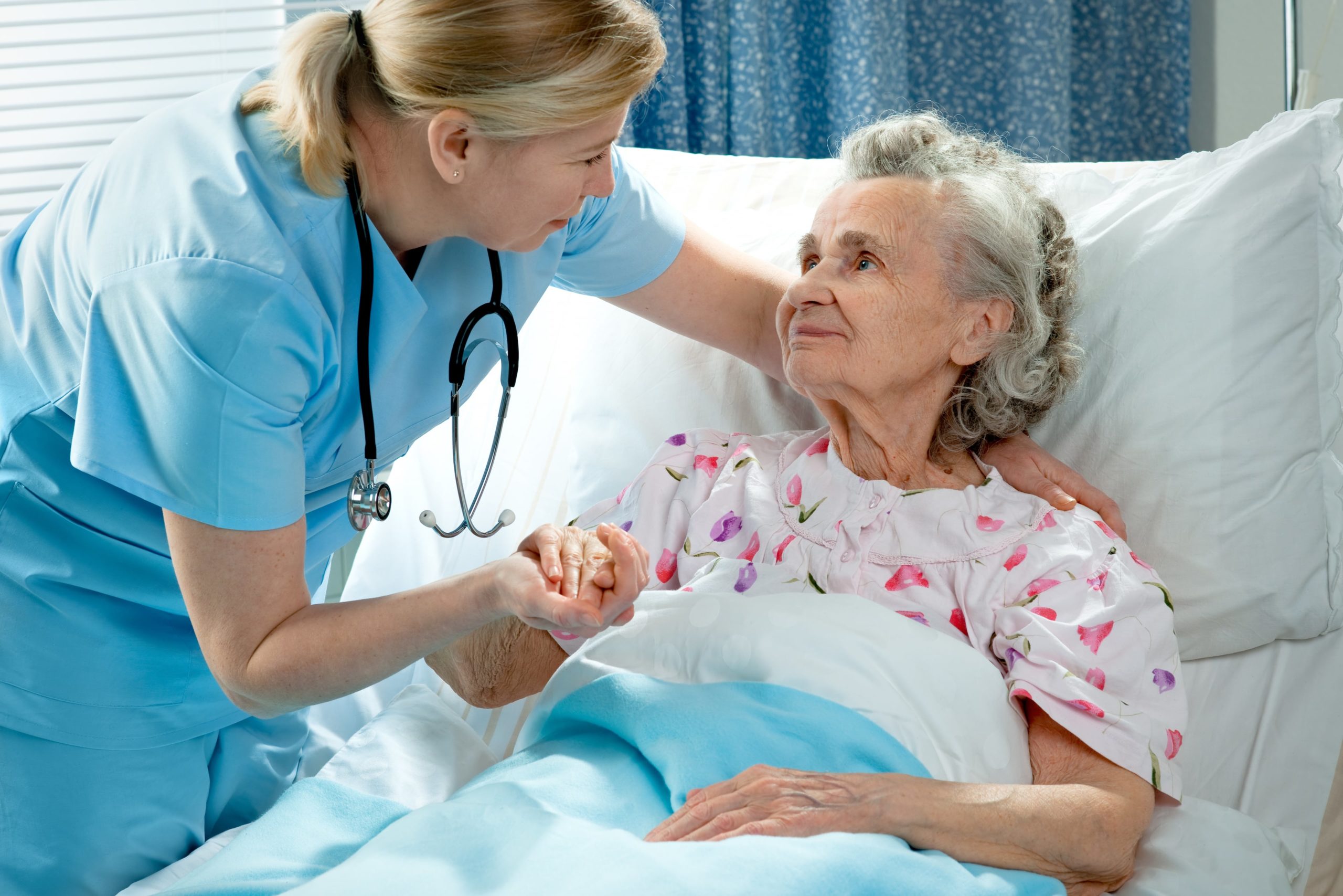 Skilled nurse assisting her elderly patient.