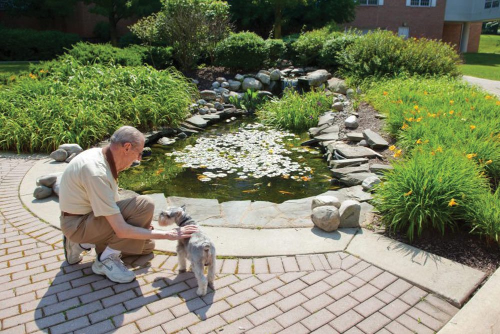 resident with dementia enjoys a walk outside with his pet