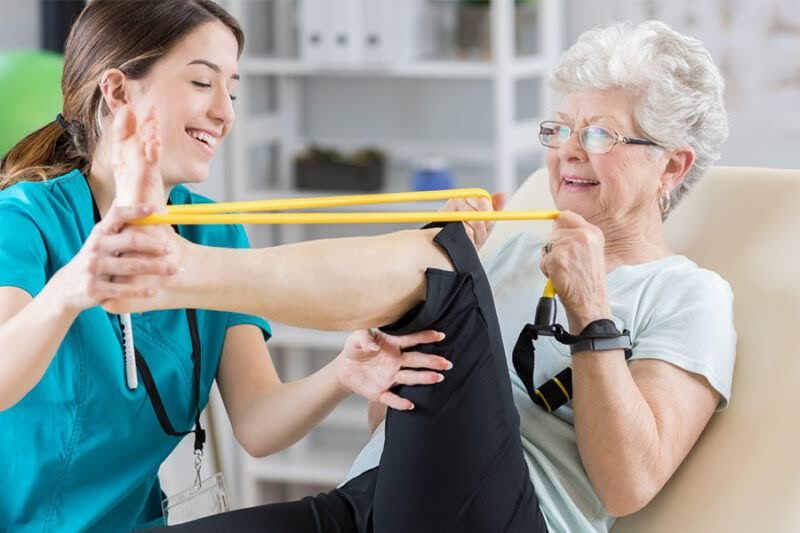 a senior woman exercising with therapist, illustrating short-term rehab for elderly near me