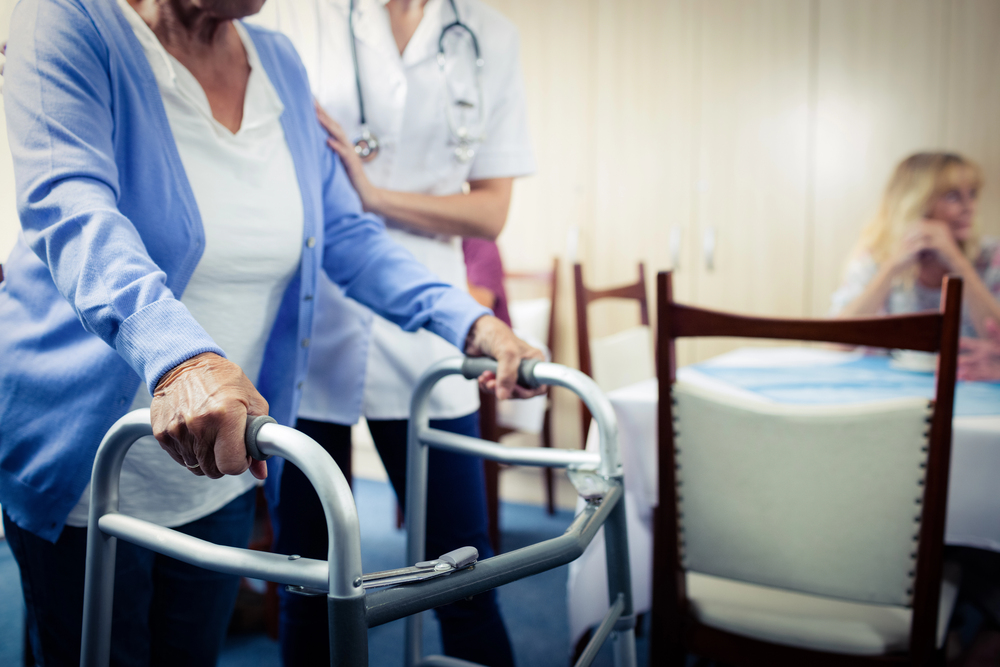 nurse assisting senior using walker during her short-term rehab at riddle village.