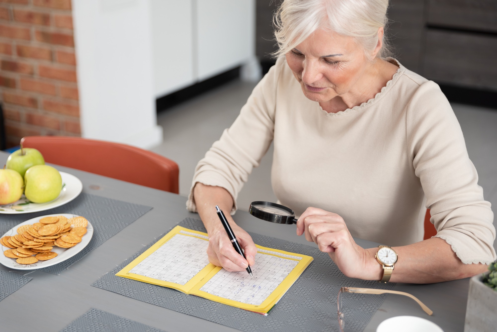 Woman enjoys solving a crossword puzzle at home